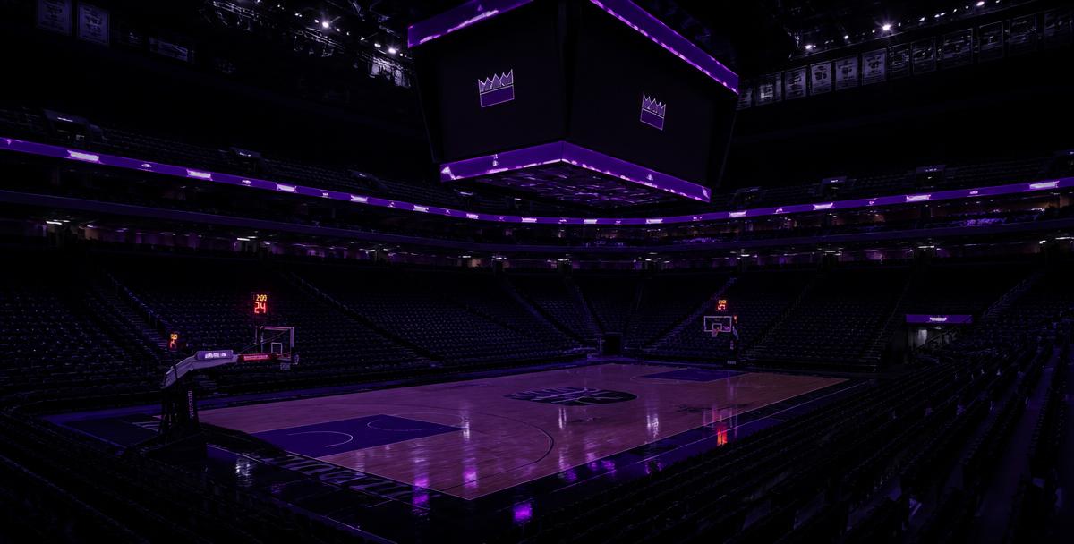 An empty modern basketball arena lit with purple accent lighting